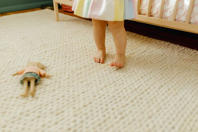 Low section of woman standing on carpet at home
