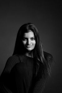 Portrait of teenage girl smiling against gray background