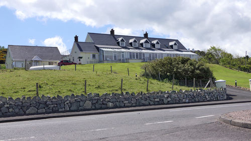 Built structure on road by houses against sky