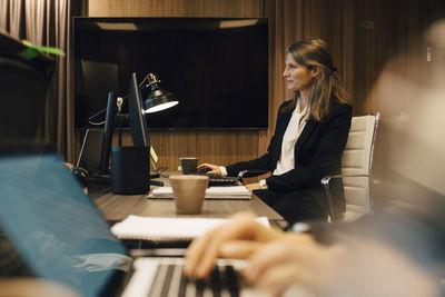 Female lawyer working on computer in board room at office