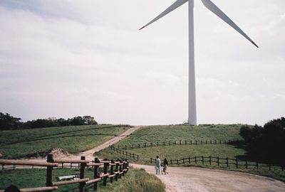 Parents walking with their child next to wind turbine