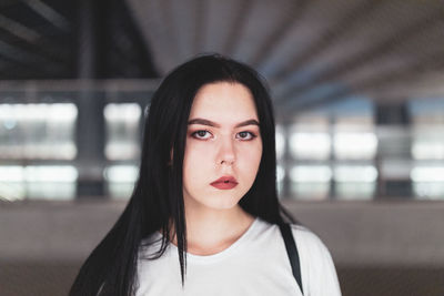 Portrait of beautiful young woman standing in building