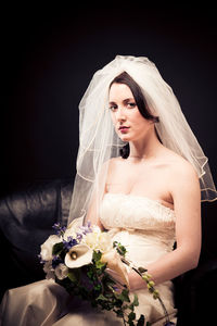 Close-up of woman with roses against white background
