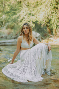 Portrait of woman sitting on rock in river