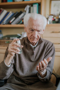 Midsection of man holding drink sitting on table