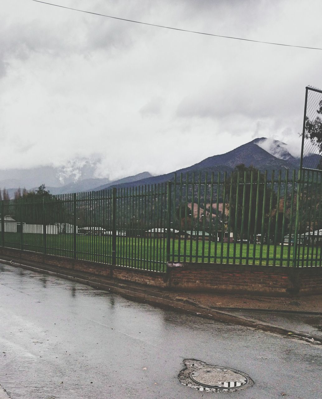 fence, sky, architecture, built structure, building exterior, cloud - sky, protection, cloudy, road, safety, transportation, security, day, outdoors, weather, landscape, nature, railing, field, no people