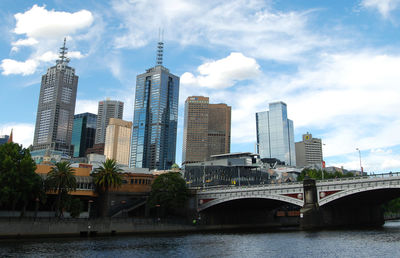 Bridge over river in city against sky