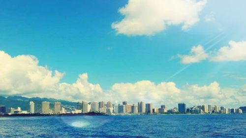 Skyscrapers in city against cloudy sky