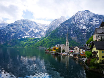 Scenic view of lake by buildings against sky