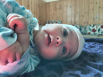 Portrait of cute baby lying on bed