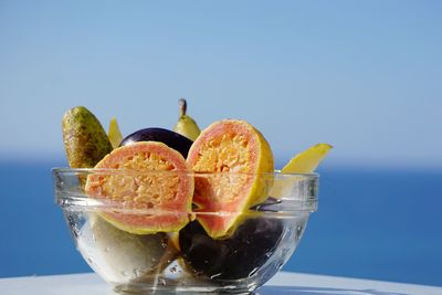 Close-up of fruits in bowl against sea