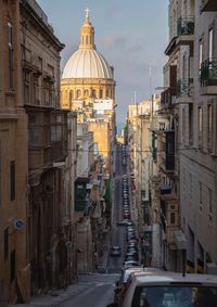 Road amidst buildings against sky