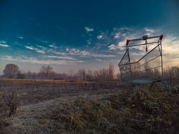 Abandoned structure on field against sky during sunset