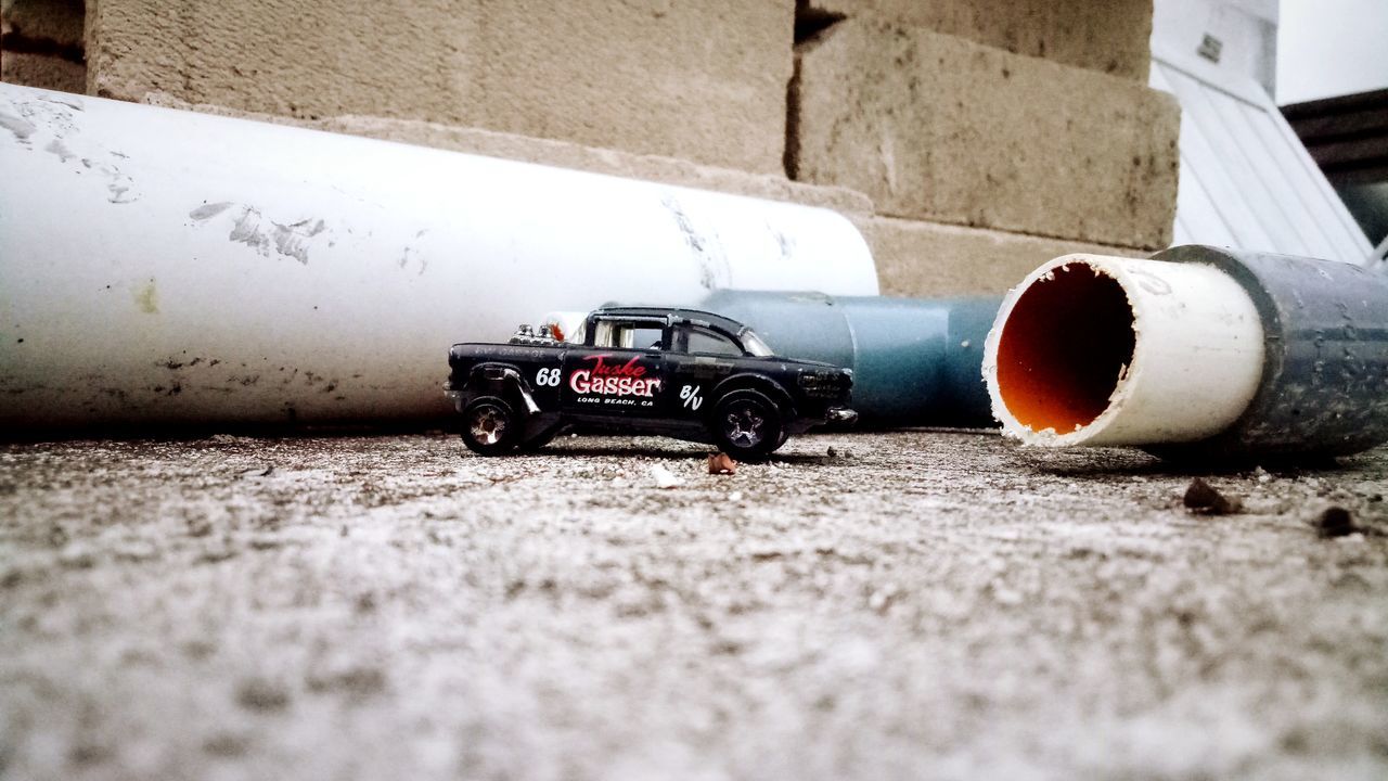 CLOSE-UP OF TOY CAR BY WALL