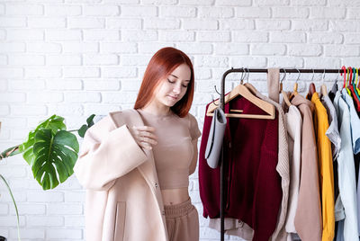 Young woman standing against wall