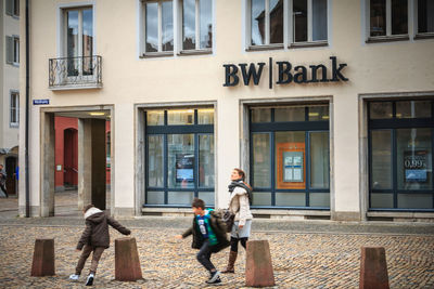 People walking on street against building in city