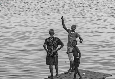 Full length of people standing by sea on jetty