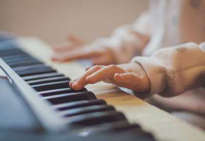 A little girl plays the electric piano.