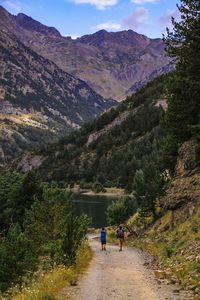 People walking on road against mountains