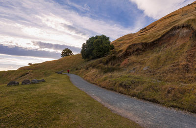 Road amidst field against sky