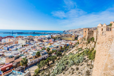 High angle view of townscape the city of almería by sea against sky, horizon in the background