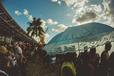 People at music concert against sky in city