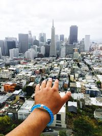 Midsection of man with cityscape in background