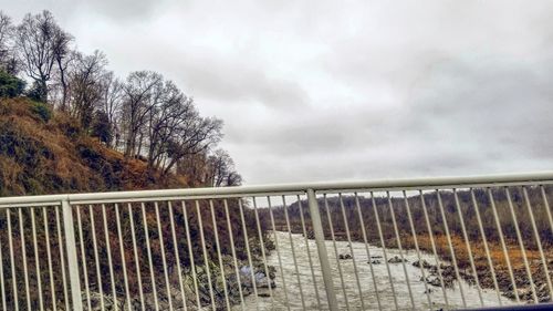 Footbridge against sky during winter