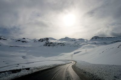 Scenic view of road against sky during winter