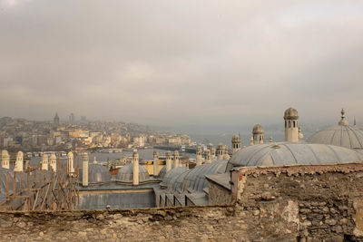 View of cityscape against cloudy sky