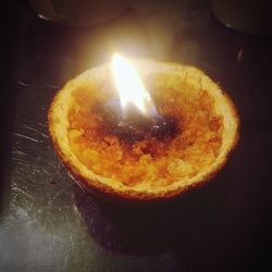 Close-up of burning candle on table