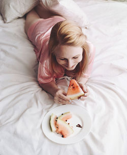 High angle view of a baby girl lying on bed