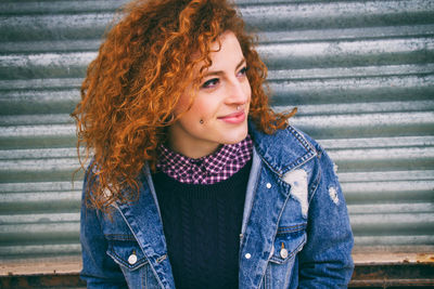 Close-up of young hipster woman against metal shutter
