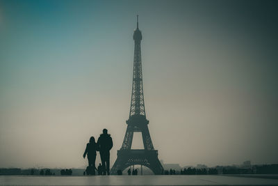 Couple standing against eiffel tower
