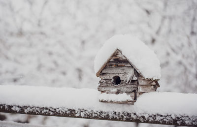 Close-up of snow covered wood on field during winter