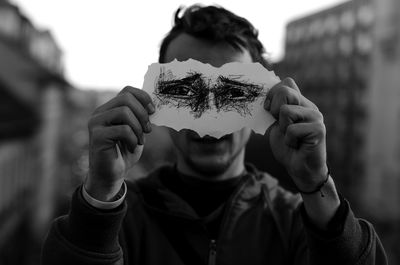 Close-up of man holding paper with sketch