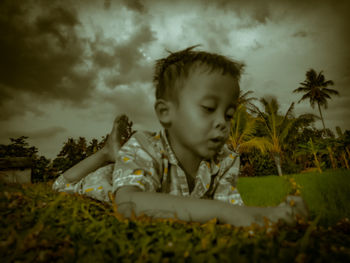 Portrait of boy looking at camera against sky