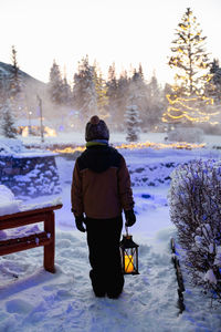 Young boy admiring christmas lights in winter at banff