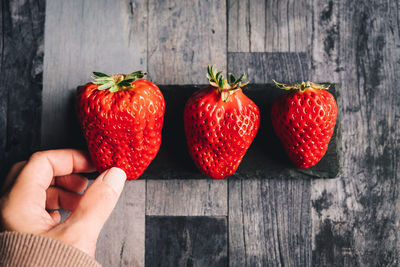 Cropped hand holding strawberries