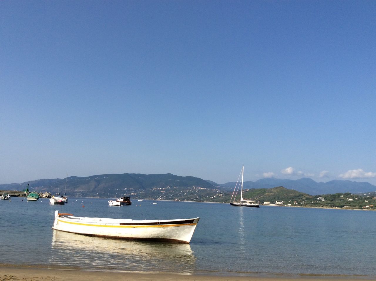 nautical vessel, transportation, boat, mode of transport, water, sea, moored, waterfront, sailboat, copy space, clear sky, sailing, mast, mountain, blue, tranquility, tranquil scene, travel, scenics, nature