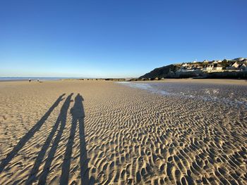 Scenic view of beach against clear blue sky