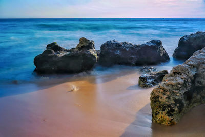 Rocks on beach against sky