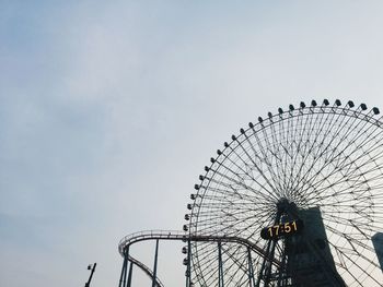 Low angle view of ferris wheel against sky