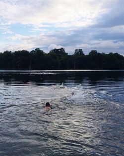 Man swimming in water at sunset