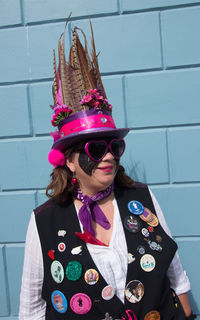 Portrait of woman wearing hat standing against wall