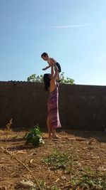 Woman holding boy in the air