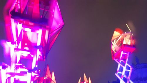 Low angle view of illuminated ferris wheel at night