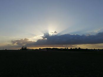 Scenic view of silhouette field against sky during sunset