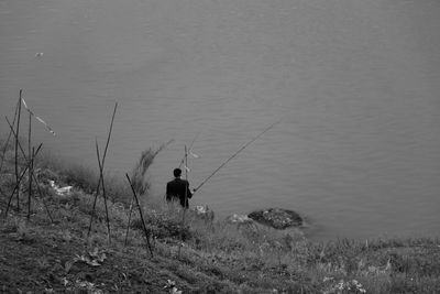 Rear view of man fishing in sea