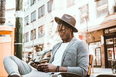 Young man using mobile phone in city